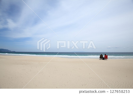 A couple relaxing on the beach A couple relaxing on the beach 127658253