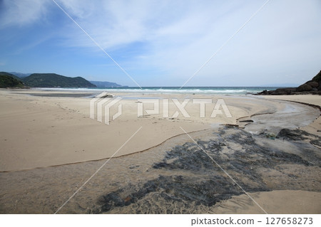 海浪拍打著海灘,河水流淌到海灘上 海浪拍打著海灘,河水流淌到海灘上 127658273