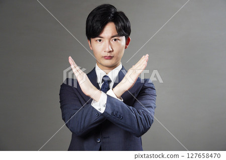 商人在黑色背景上做十字手勢 127658470