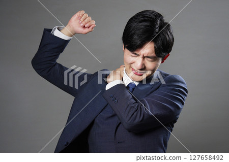 Businessman stiff shoulders black background 127658492