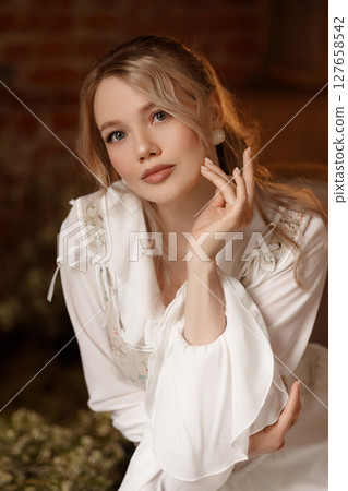 Woman in white dress sitting on chair in conceptual indoor swamp art setup Woman in white dress sitting on chair in conceptual indoor swamp art setup 127658542