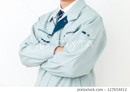 一位身穿綠色工作服、雙臂交叉的中年男性商人 127658812