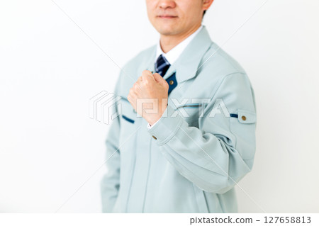 一位身穿綠色工作服、揮拳的中年男性商人 127658813