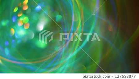 Green glow. Blur radiance. Multicolored orange blue yellow lines sparks lens flare on bokeh light abstract optical background. Green glow. Blur radiance. Multicolored orange blue yellow lines sparks lens flare on bokeh light abstract optical background. 127658877