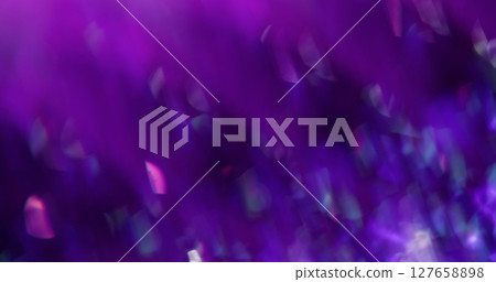 Defocused crystal sparkle. Iridescent glow. Abstract prism bokeh light reflection with rainbow lens flare on blurred blue purple multicolored background. 127658898