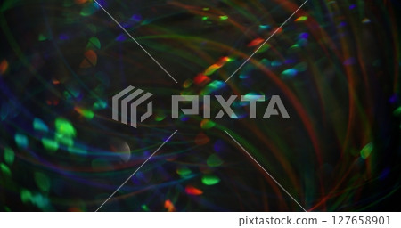 Blurred glare light. Art color. Majestic green orange blue kaleidoscope lens flare swirling on modern bokeh abstract background. Blurred glare light. Art color. Majestic green orange blue kaleidoscope lens flare swirling on modern bokeh abstract background. 127658901