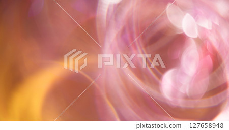 Swirling circle. Defocused radiance. Multicolored pink yellow lens flare on blurred bokeh light abstract background. Swirling circle. Defocused radiance. Multicolored pink yellow lens flare on blurred bokeh light abstract background. 127658948