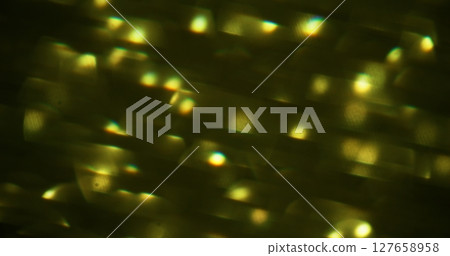 Blurred sparkle. Festive glimmer. Green colorful gleaming luminous circling lens flare bokeh light abstract background. 127658958