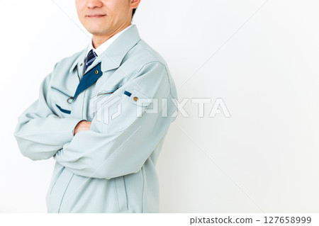 一位身穿綠色工作服、雙臂交叉的中年男性商人 一位身穿綠色工作服、雙臂交叉的中年男性商人 127658999