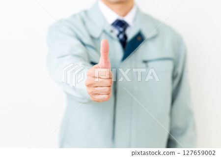 A middle-aged male businessman wearing green work clothes giving a thumbs up 127659002