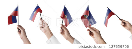 The Haiti flag in hand in different angles on a white background 127659706