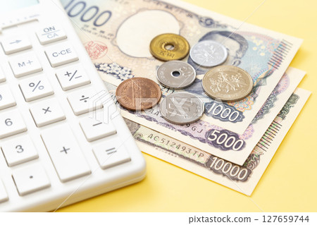 黃色背景中的日本貨幣和計算器 127659744