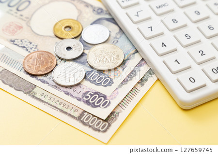 黃色背景中的日本貨幣和計算器 127659745