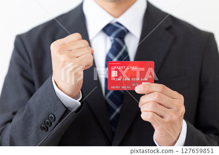 西裝革履的商人，手裡拿著信用卡，揮拳致意 127659851