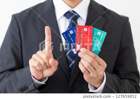 西裝革履的商人，手裡拿著信用卡，食指向上 127659852