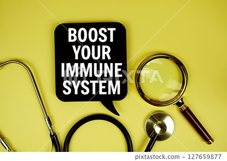 Boost Your Immune System text message on paper card with stethoscope magnifying glass on yellow background 127659877