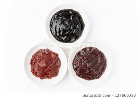 Doubanjiang, sweet bean paste and gochujang in small dishes on a white background Doubanjiang, sweet bean paste and gochujang in small dishes on a white background 127660350