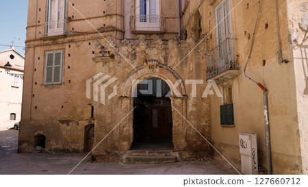 Ancient arch decorating a weathered building in Tropea, Italy 127660712