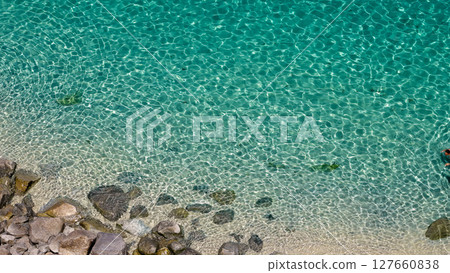 Crystal clear turquoise water gently hitting the rocky shore in Tropea, Calabria, Italy Crystal clear turquoise water gently hitting the rocky shore in Tropea, Calabria, Italy 127660838