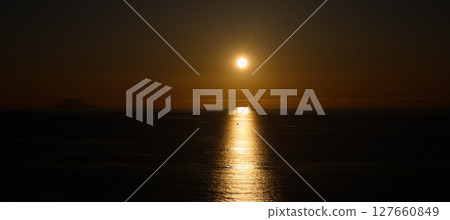 Stromboli Volcano emerging from the sea at sunset, reflecting on the Tyrrhenian Sea near Tropea 127660849