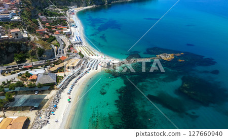 Aerial view of Tropea, Calabria, showing crystal clear turquoise water and beach umbrellas Aerial view of Tropea, Calabria, showing crystal clear turquoise water and beach umbrellas 127660940