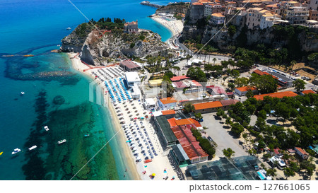 Aerial view of Tropea, Calabria, showing beach umbrellas, turquoise water, and cityscape 127661065