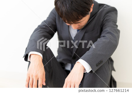 一位身穿西裝、患有憂鬱症的中年男性商人 127661214