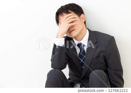 A middle-aged male businessman in a suit suffering from depression A middle-aged male businessman in a suit suffering from depression 127661221