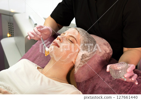 Esthetician applies fanbrush foamy mask to client's chin Esthetician applies fanbrush foamy mask to client's chin 127661440