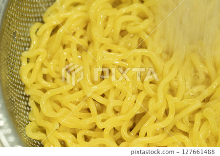 Boiled chilled Chinese noodles being rinsed in cold water (stock photo) Boiled chilled Chinese noodles being rinsed in cold water (stock photo) 127661488