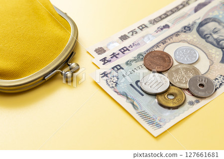 黃色背景中的日本貨幣和錢包 黃色背景中的日本貨幣和錢包 127661681