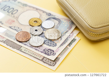 黃色背景中的日本貨幣和錢包 黃色背景中的日本貨幣和錢包 127661722