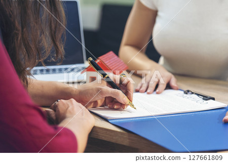 Close up Team Businesswoman hands partners sign contract with success business deal. Diversity Businesswoman teams handshake together. Partnership teamwork meeting signing contract business concept 127661809