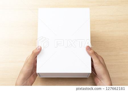 手拿著一個白色的盒子 手拿著一個白色的盒子 127662181
