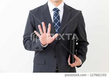 一位身穿西裝的中年男性商人，手裡拿著黑色文件，伸出五根手指 127662193