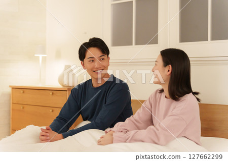 晚上在床上聊天的夫婦 晚上在床上聊天的夫婦 127662299