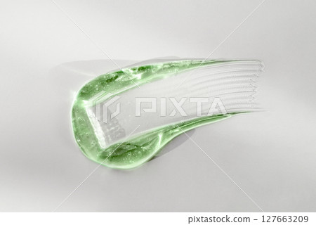 Green cosmetic smear gel texture on a white background 127663209