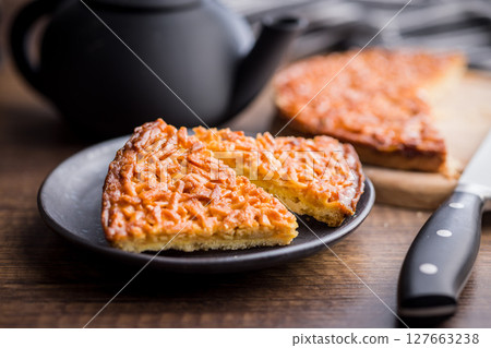 Sweet almond pie on plate on wooden table. 127663238