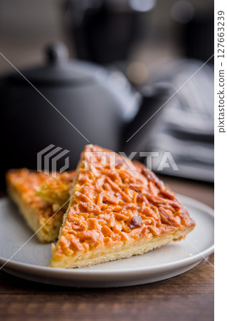 Sweet almond pie on plate on wooden table. 127663239