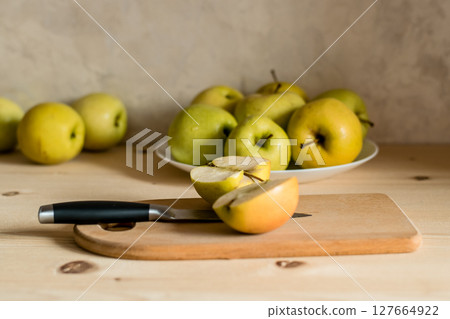 A green apple cut in half on a wooden board 127664922