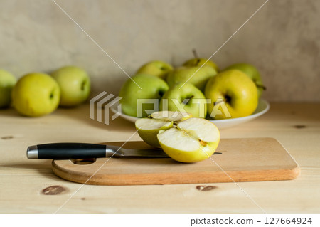 An apple is cut on a wooden board 127664924