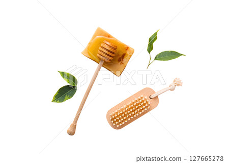 Wooden honey stick rests on honey and leaves, isolated on white, PNG 127665278
