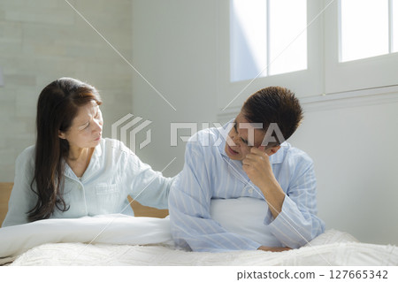 Senior couple in poor health waking up 127665342