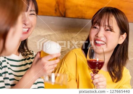 Women drinking at a girls' party Women drinking at a girls' party 127665440