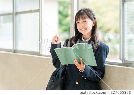 Elementary school, junior high school, and high school girls holding books in school corridors Elementary school, junior high school, and high school girls holding books in school corridors 127665538