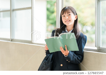 Elementary school, junior high school, and high school girls holding books in school corridors Elementary school, junior high school, and high school girls holding books in school corridors 127665547
