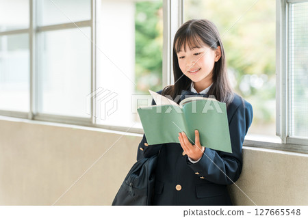 Elementary school, junior high school, and high school girls holding books in school corridors Elementary school, junior high school, and high school girls holding books in school corridors 127665548