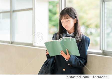 Elementary school, junior high school, and high school girls holding books in school corridors Elementary school, junior high school, and high school girls holding books in school corridors 127665550