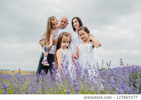 A young family is enjoying their time in the enchanting lavender field A young family is enjoying their time in the enchanting lavender field 127665577