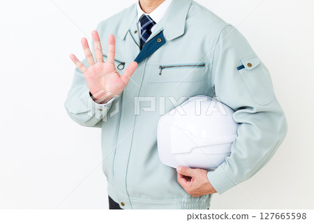 A middle-aged male businessman wearing green work clothes, holding a helmet and pointing up five fingers 127665598